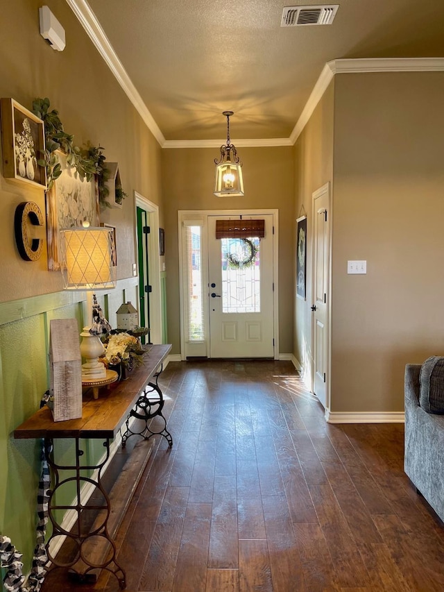 foyer with dark hardwood / wood-style flooring, crown molding, and a textured ceiling