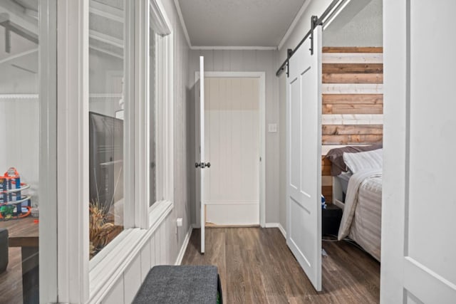 entryway with wooden walls, a barn door, dark hardwood / wood-style flooring, and a textured ceiling