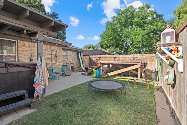 view of yard featuring a playground, a patio, and a hot tub