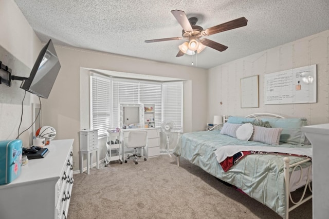 bedroom with light carpet, ceiling fan, and a textured ceiling