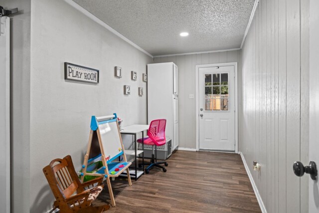 entryway featuring crown molding, dark wood-type flooring, and a textured ceiling