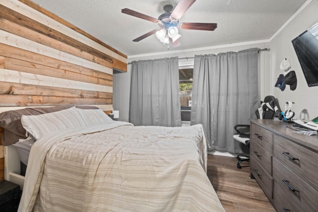 bedroom featuring crown molding, dark hardwood / wood-style floors, a textured ceiling, and wood walls