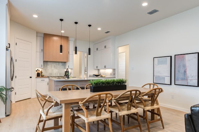 dining space with sink and light hardwood / wood-style flooring