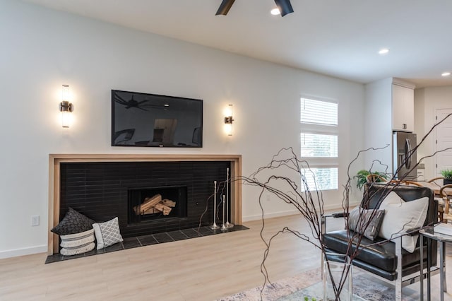 living room featuring ceiling fan and light hardwood / wood-style floors