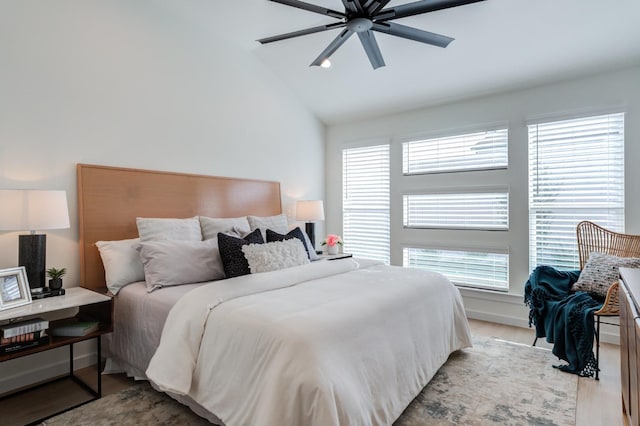 bedroom with ceiling fan, lofted ceiling, multiple windows, and light hardwood / wood-style flooring