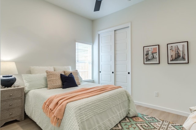 bedroom with ceiling fan, light hardwood / wood-style floors, and a closet