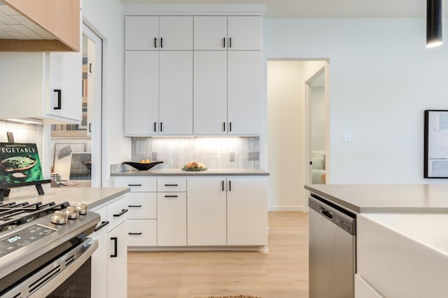 kitchen featuring white cabinetry, stainless steel appliances, and backsplash