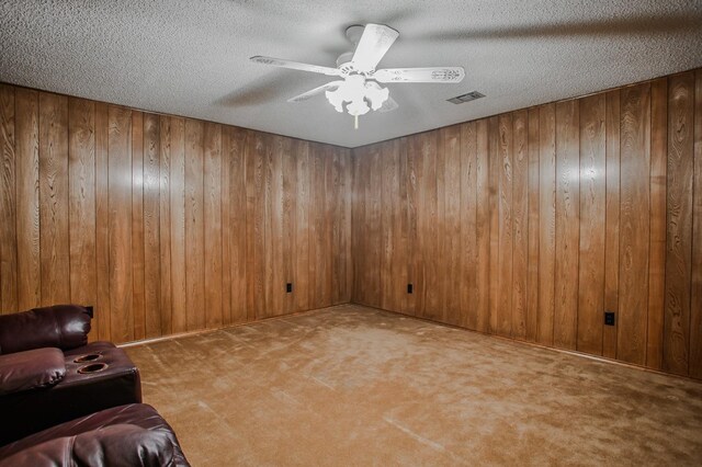 unfurnished living room featuring a brick fireplace, lofted ceiling with skylight, ceiling fan, and wood walls