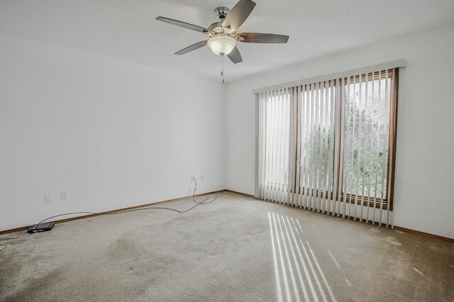 unfurnished room with light colored carpet and ceiling fan