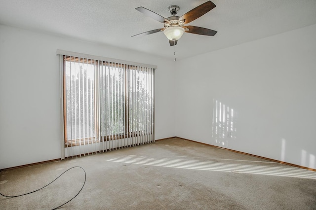 carpeted spare room with ceiling fan and a textured ceiling