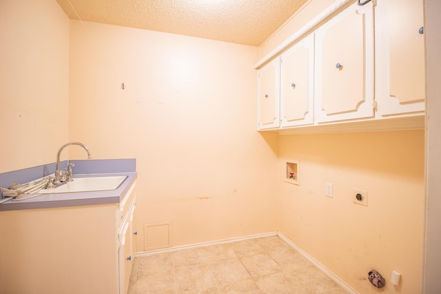 5720 71st St, Lubbock, TX 79424 - laundry area featuring cabinet space, hookup for an electric dryer, washer hookup, a textured ceiling, and hookup for a gas dryer