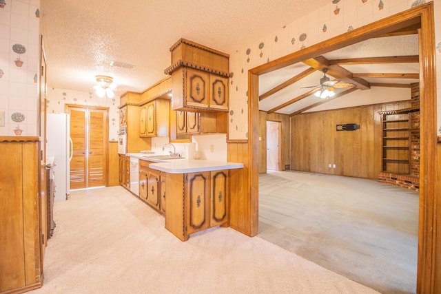 5720 71st St, Lubbock, TX 79424 - kitchen with light colored carpet, white appliances, a textured ceiling, a ceiling fan, and wooden walls