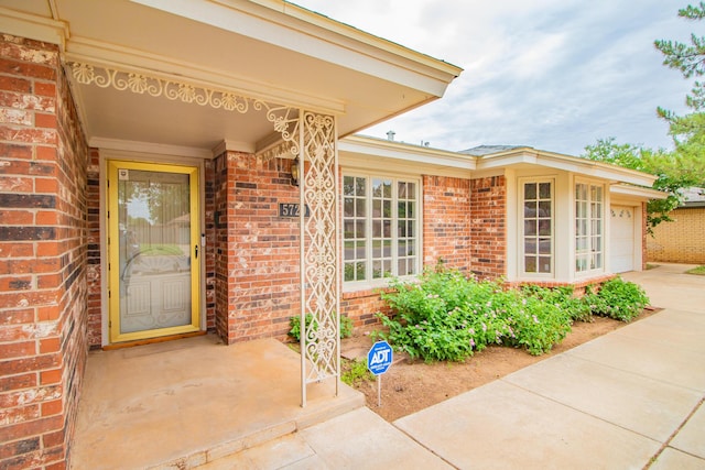 5720 71st St, Lubbock, TX 79424 - doorway to property with brick siding, driveway, and a garage