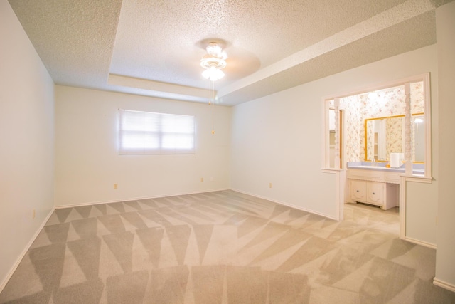 5720 71st St, Lubbock, TX 79424 - empty room featuring light carpet, a textured ceiling, ceiling fan, and a raised ceiling