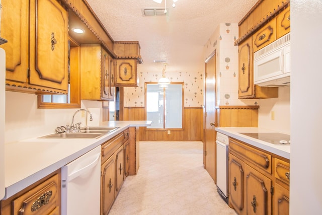 5720 71st St, Lubbock, TX 79424 - kitchen with white appliances, a textured ceiling, a wainscoted wall, brown cabinets, and light countertops