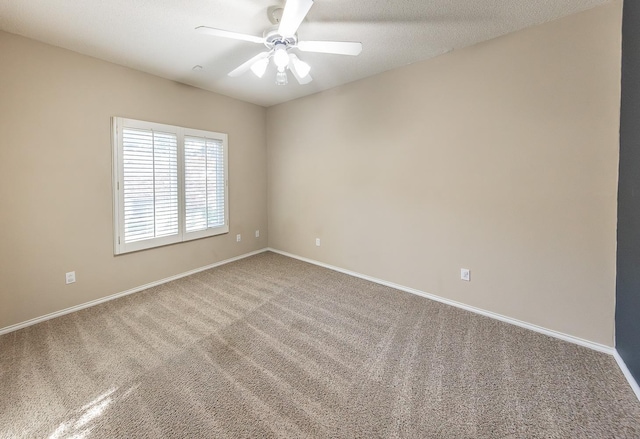 carpeted empty room with a ceiling fan, a textured ceiling, and baseboards