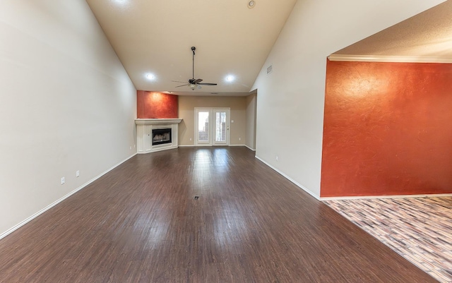 unfurnished living room featuring dark wood-type flooring, a fireplace, baseboards, and ceiling fan