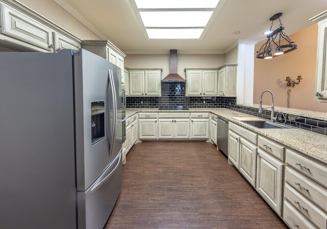 kitchen with dark wood-type flooring, hanging light fixtures, stainless steel appliances, premium range hood, and a sink