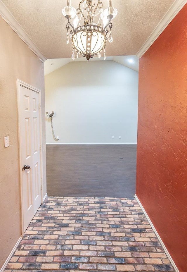 hallway featuring brick floor, lofted ceiling, a notable chandelier, and crown molding