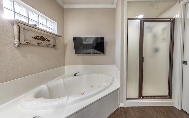 bathroom with ornamental molding, a stall shower, a tub with jets, and wood finished floors