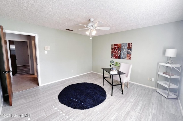 7907 Knoxville Ave, Lubbock, TX 79423 - home office with ceiling fan, a textured ceiling, baseboards, and light wood-style floors