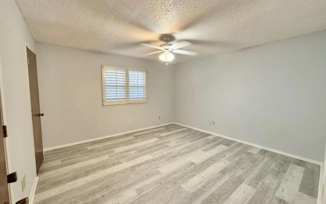 empty room featuring a textured ceiling, light hardwood / wood-style flooring, and ceiling fan