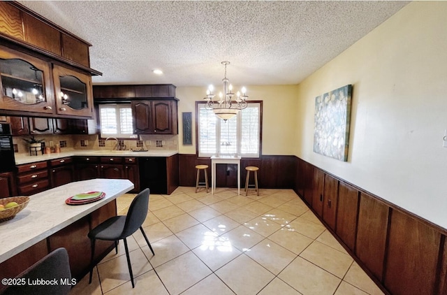 7907 Knoxville Ave, Lubbock, TX 79423 - kitchen with wainscoting, a textured ceiling, light countertops, a chandelier, and a sink