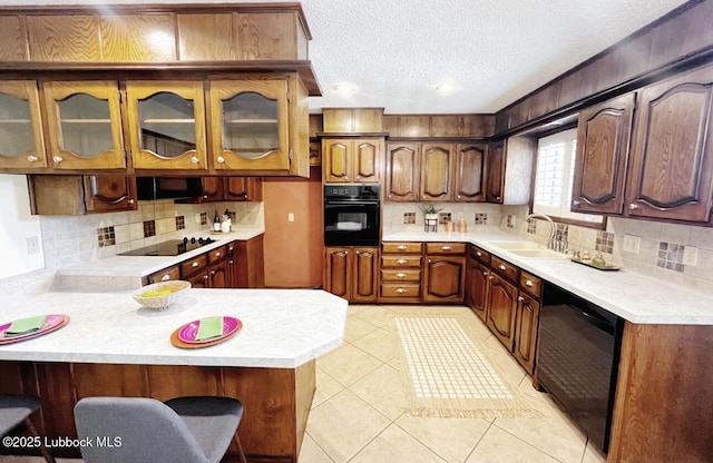 7907 Knoxville Ave, Lubbock, TX 79423 - kitchen featuring black appliances, a sink, a peninsula, light countertops, and a textured ceiling