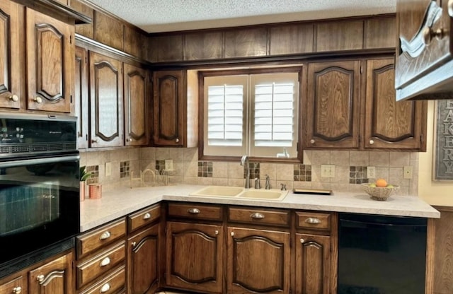 kitchen with sink, backsplash, dark brown cabinetry, black appliances, and a textured ceiling