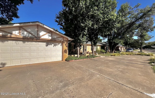 7907 Knoxville Ave, Lubbock, TX 79423 - view of side of home with brick siding, concrete driveway, and an attached garage