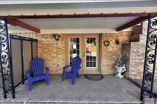 7907 Knoxville Ave, Lubbock, TX 79423 - doorway to property featuring brick siding, a patio area, and french doors