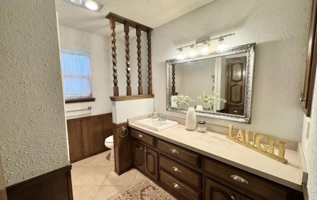 bathroom featuring vanity, toilet, tile patterned flooring, and a textured ceiling