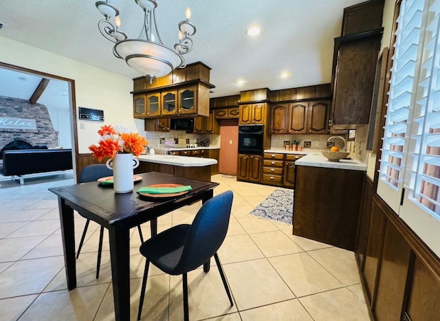 kitchen featuring dark brown cabinetry, decorative backsplash, black appliances, and light tile patterned flooring