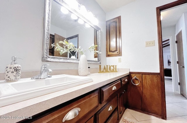 7907 Knoxville Ave, Lubbock, TX 79423 - bathroom featuring double vanity, tile patterned flooring, wainscoting, and wooden walls