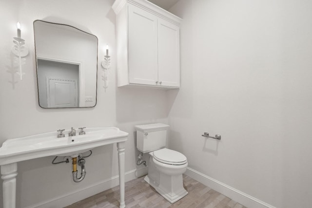 bathroom with hardwood / wood-style flooring and toilet