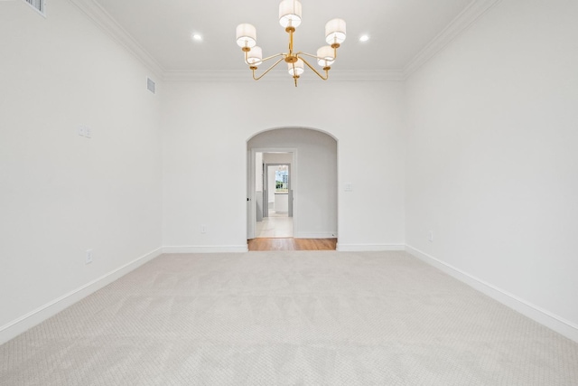 empty room with light carpet, ornamental molding, and an inviting chandelier