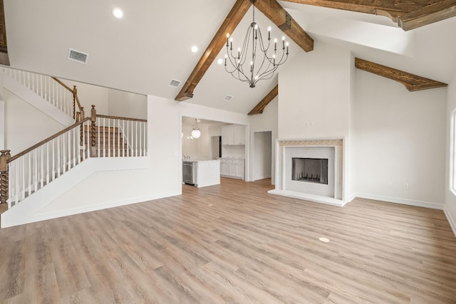 unfurnished living room featuring an inviting chandelier, light hardwood / wood-style flooring, high vaulted ceiling, and beamed ceiling