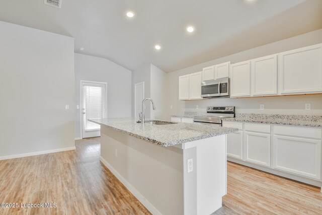 2012 Kenwood Ave, Lubbock, TX 79407 - kitchen featuring stainless steel appliances, lofted ceiling, light wood-style floors, white cabinetry, and a kitchen island with sink