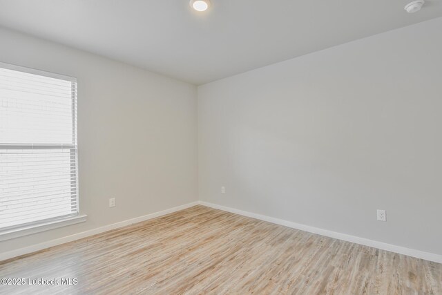 2012 Kenwood Ave, Lubbock, TX 79407 - spare room featuring wood finished floors, a smoke detector, and healthy amount of natural light