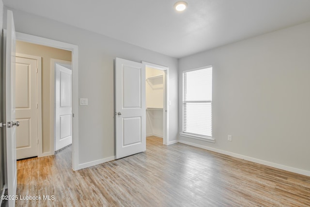 2012 Kenwood Ave, Lubbock, TX 79407 - unfurnished bedroom featuring light wood-style flooring, a spacious closet, and a closet