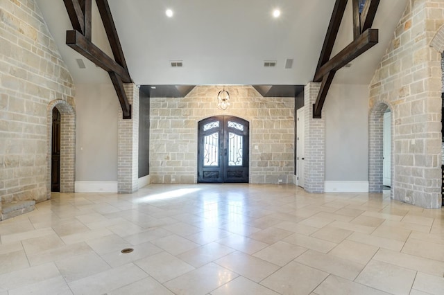 tiled foyer with french doors, beam ceiling, and high vaulted ceiling