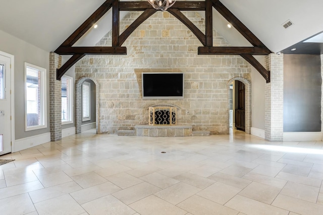 unfurnished living room featuring beam ceiling, a stone fireplace, high vaulted ceiling, and light tile patterned flooring