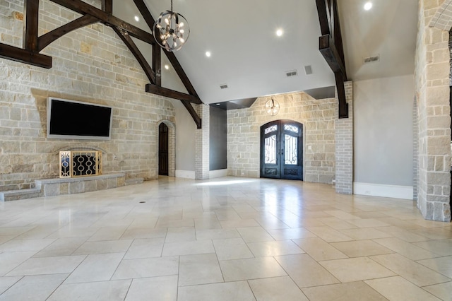 unfurnished living room with beamed ceiling, light tile patterned floors, high vaulted ceiling, and french doors