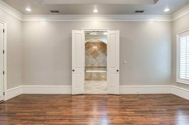 spare room featuring crown molding and dark hardwood / wood-style floors