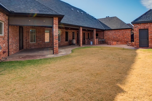 back of house with a lawn and a patio