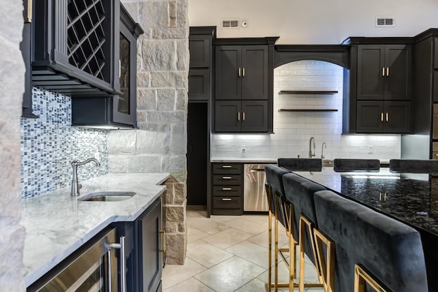 kitchen with sink, stainless steel dishwasher, beverage cooler, and light stone countertops