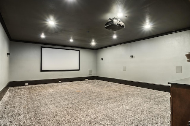 carpeted home theater room featuring ornamental molding