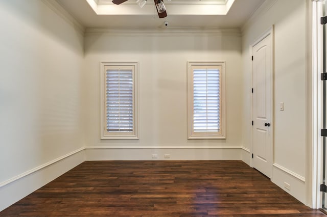 spare room featuring dark wood-type flooring, ornamental molding, a raised ceiling, and ceiling fan