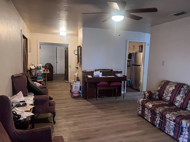 living room featuring wood-type flooring and ceiling fan