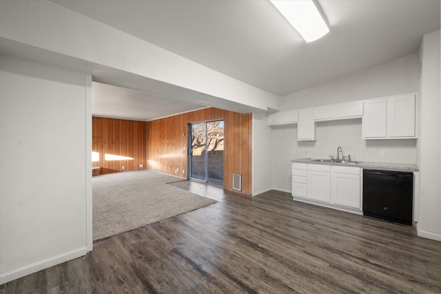 kitchen featuring vaulted ceiling, dark hardwood / wood-style flooring, wooden walls, dishwasher, and white cabinets